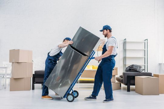 Umzugsleute transportieren einen Kühlschrank