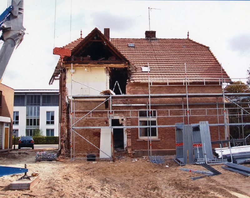 Ein Backsteingebäude mit Gerüsten darum herum wird abgerissen