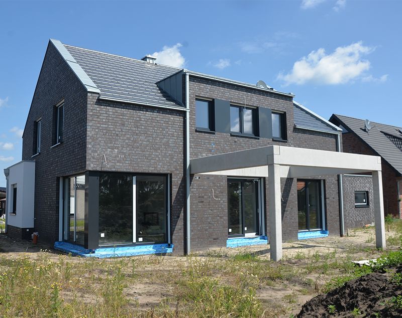 Ein Backsteinhaus mit einer Pergola davor