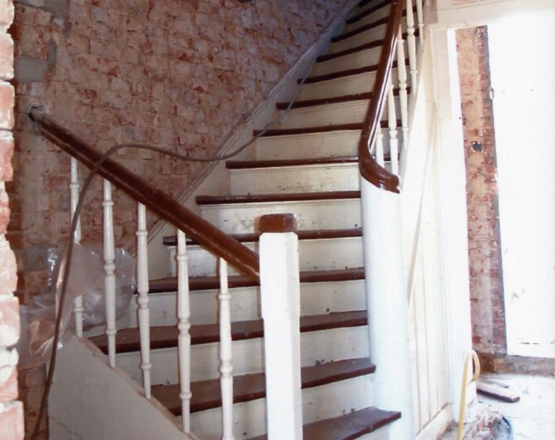 Eine Treppe mit weißem Geländer und Holzstufen