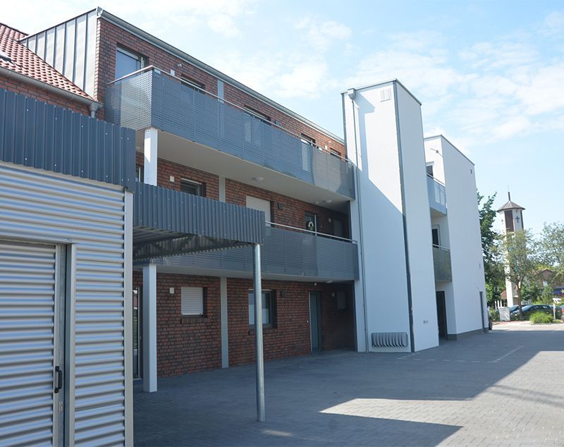 Ein großes Backsteingebäude mit Balkonen und einer Garage