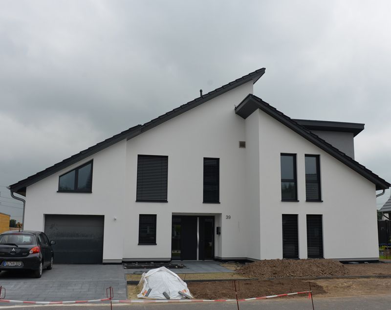 Ein weißes Haus mit einem davor geparkten Auto