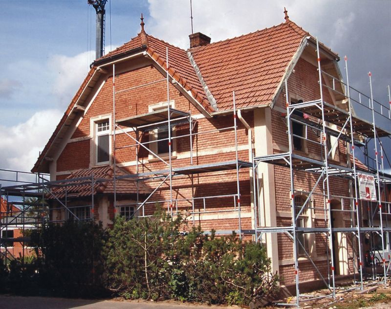 Ein großes Backsteinhaus mit Gerüst darum