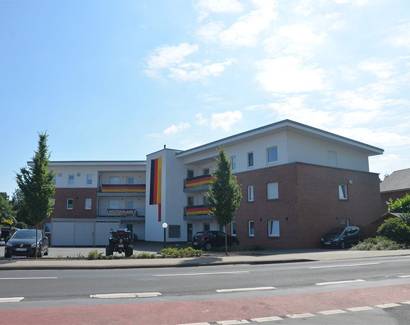 Ein Jeep steht vor einem großen Wohnhaus