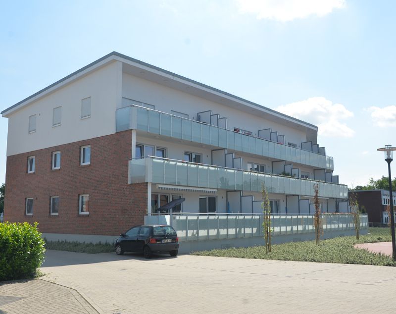 Ein Auto steht vor einem großen Wohnhaus