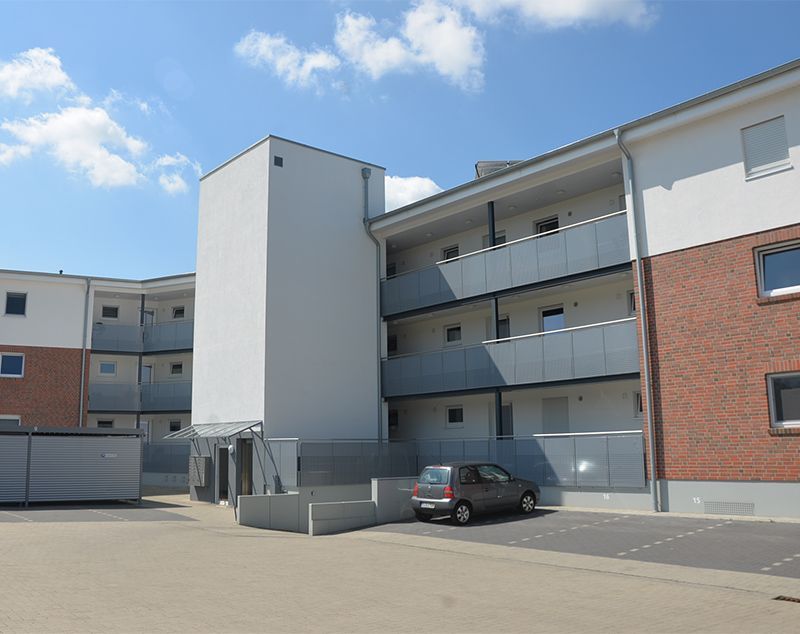 Ein Auto steht vor einem großen Wohnhaus