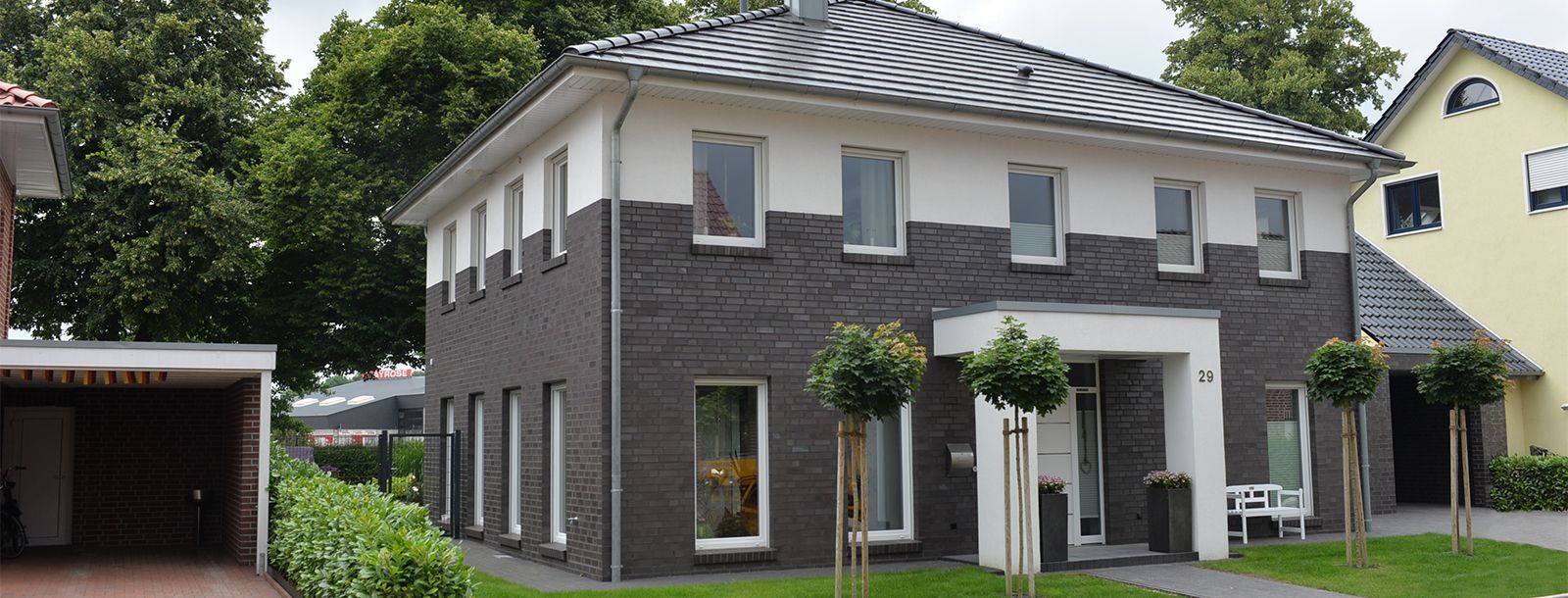 Ein großes Backsteinhaus mit weißen Verzierungen und schwarzem Dach