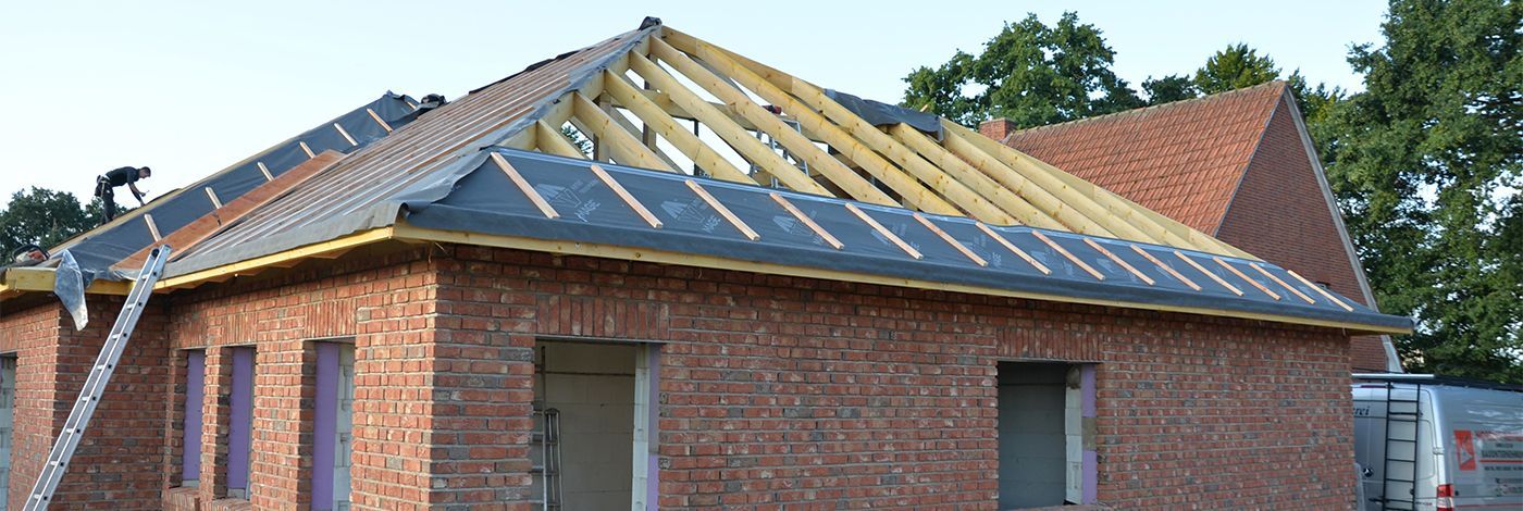 Ein im Bau befindliches Backsteingebäude mit Holzdach.