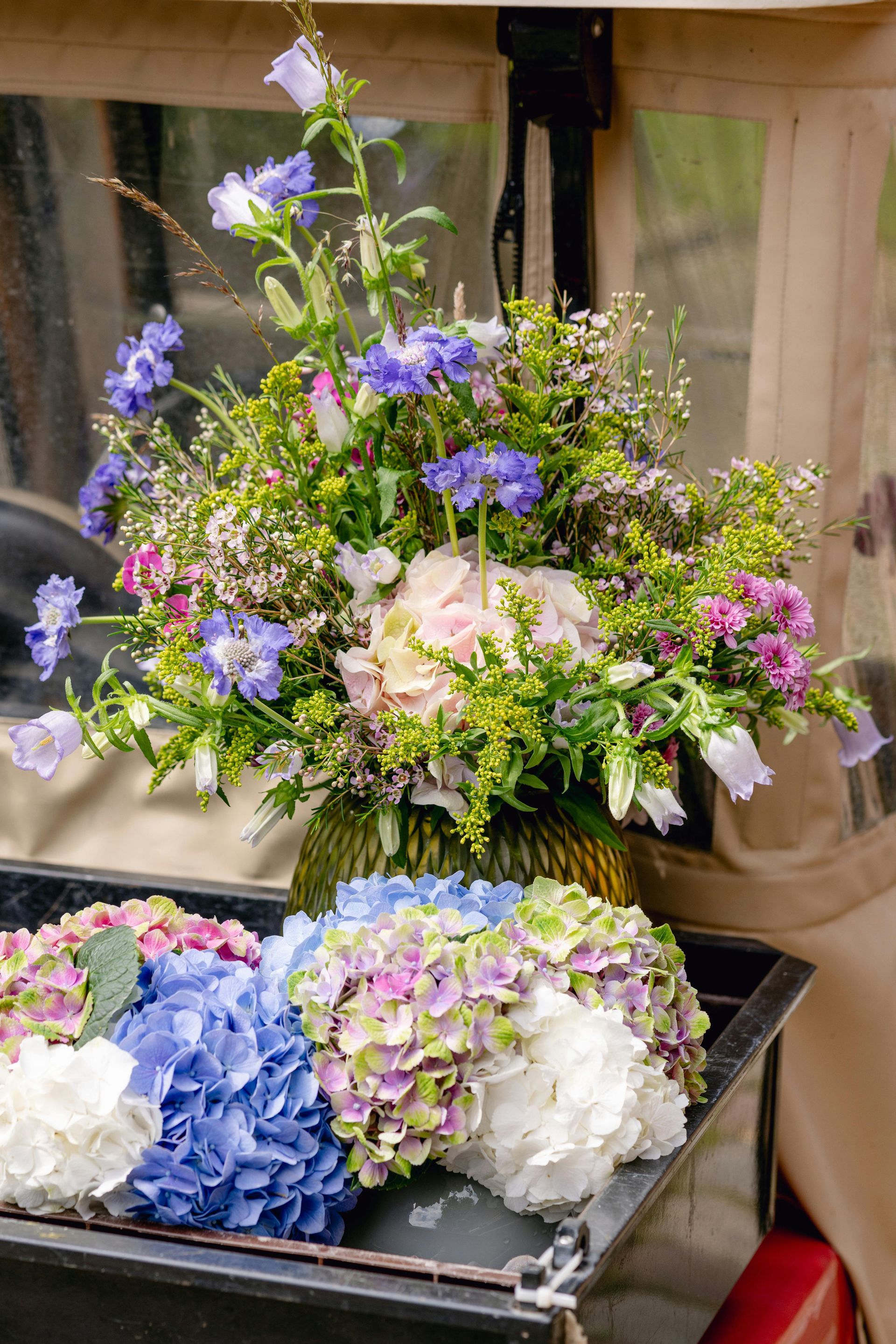 Auf der Ladefläche eines Golfwagens liegt ein Blumenstrauß.