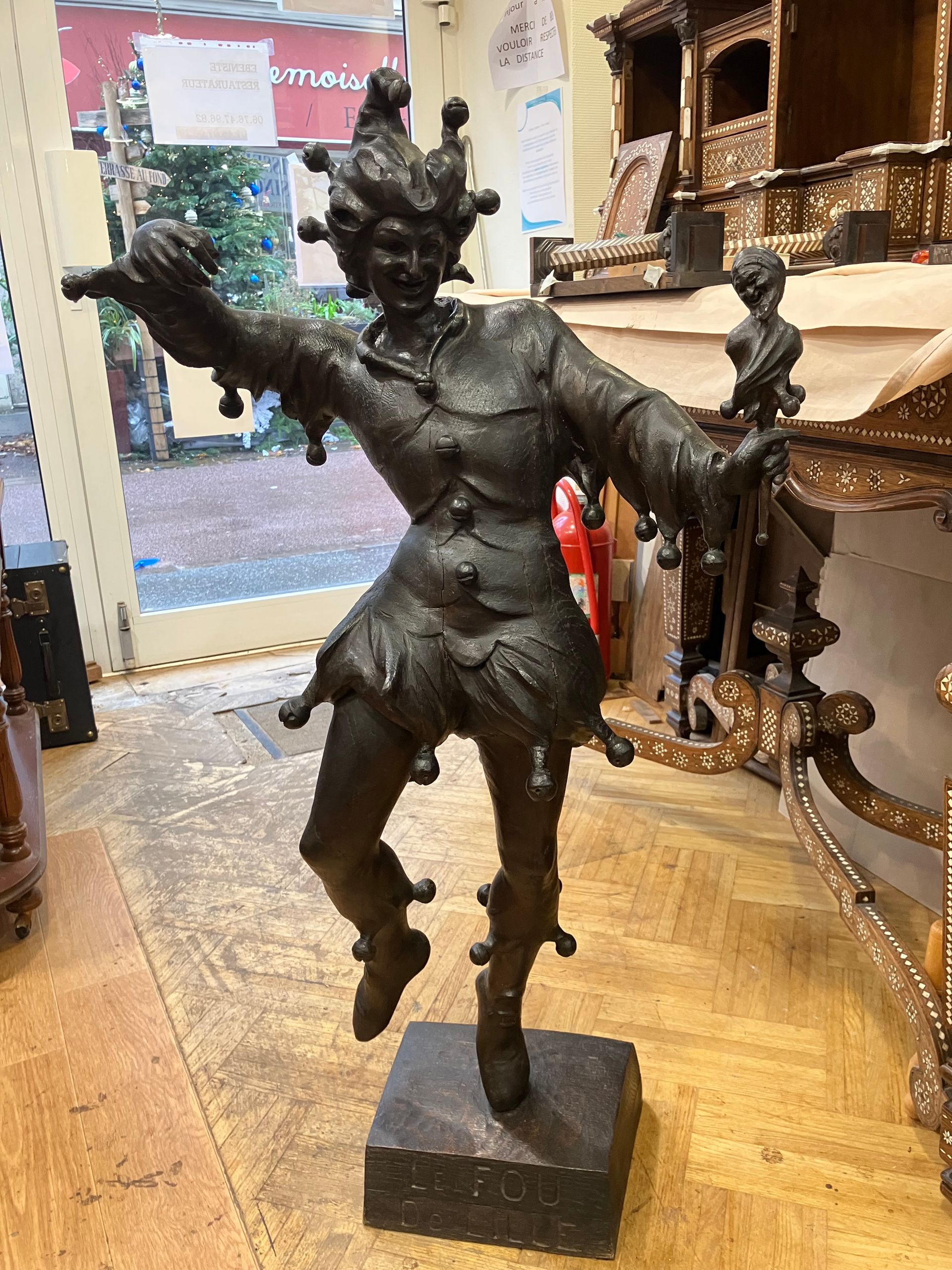 Statue de danseuse en bronze, les bras tendus, exposée sur un socle dans une boutique.