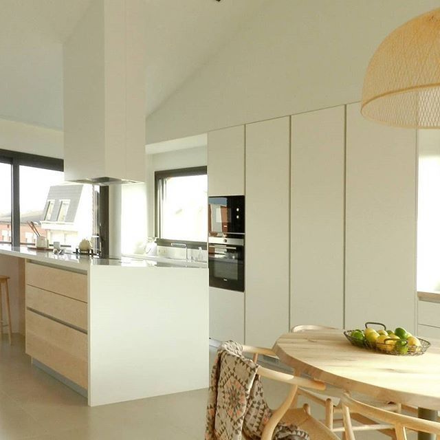 Una cocina con gabinetes blancos y una mesa de madera.