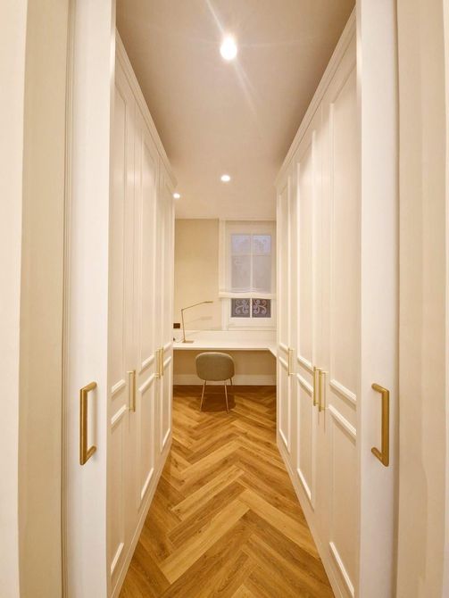 Una puerta de madera se abre a una habitación con una escalera.