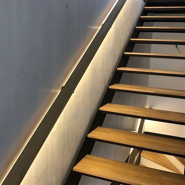 Una escalera con escalones de madera y barandilla de metal