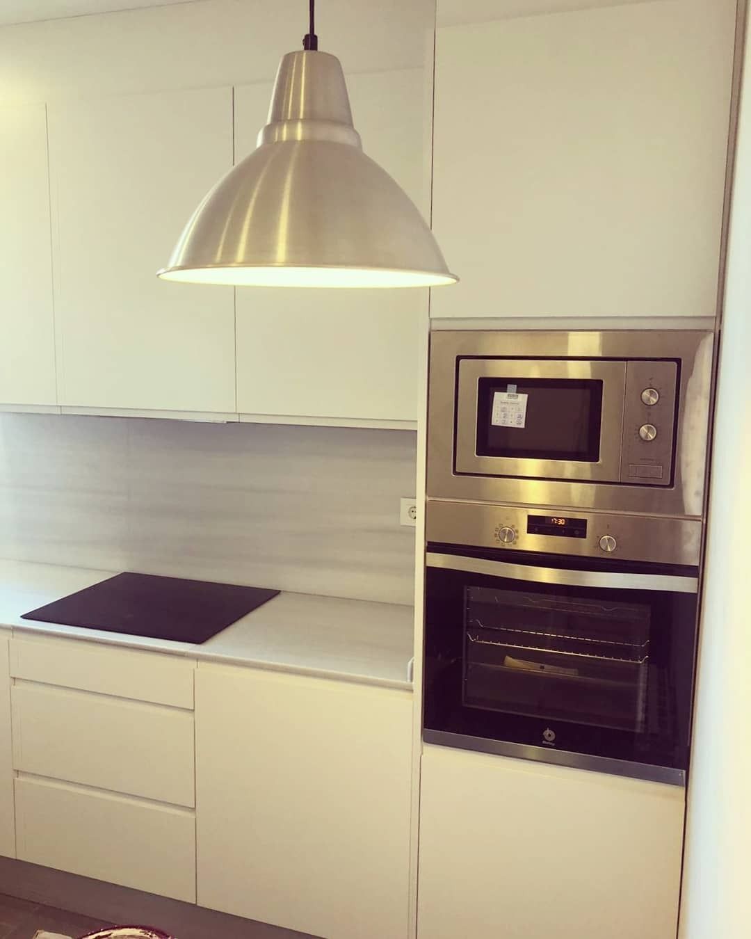 Una cocina con electrodomésticos de acero inoxidable y gabinetes blancos.