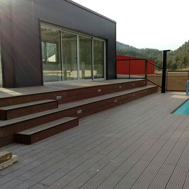 Una terraza con escaleras que conducen a una piscina.