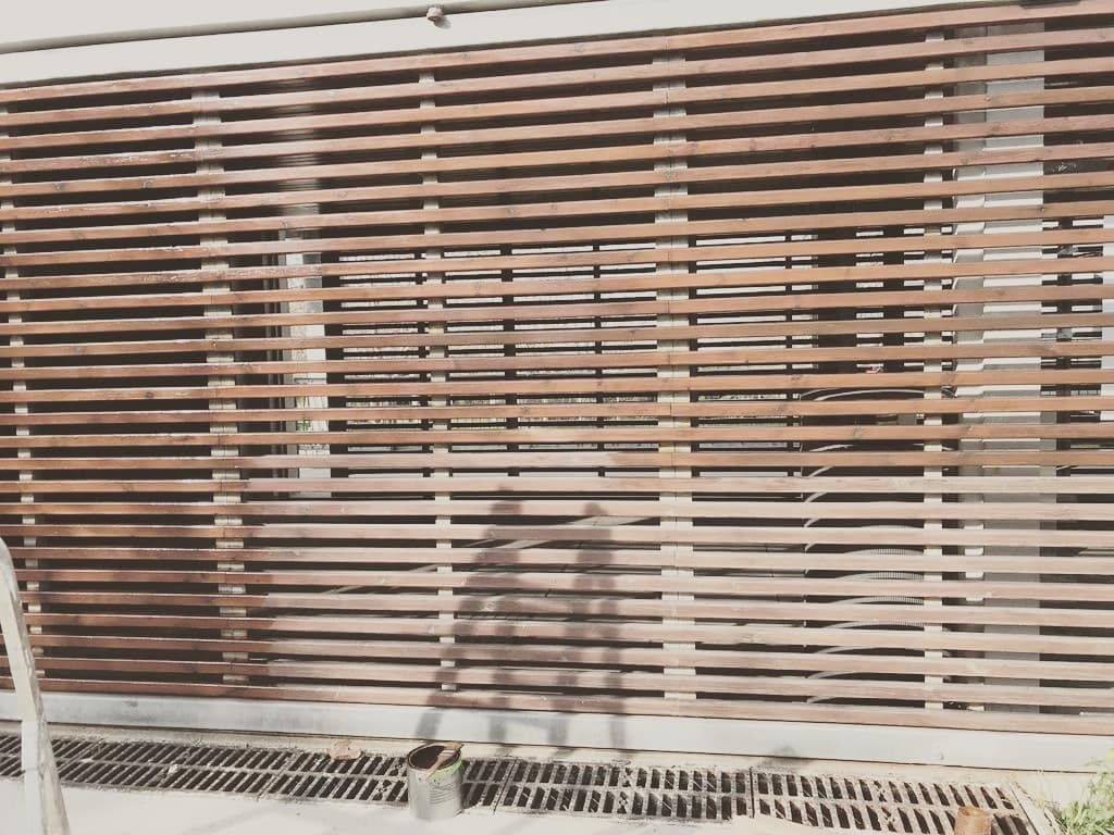 La sombra de una persona se proyecta sobre una pared de madera.