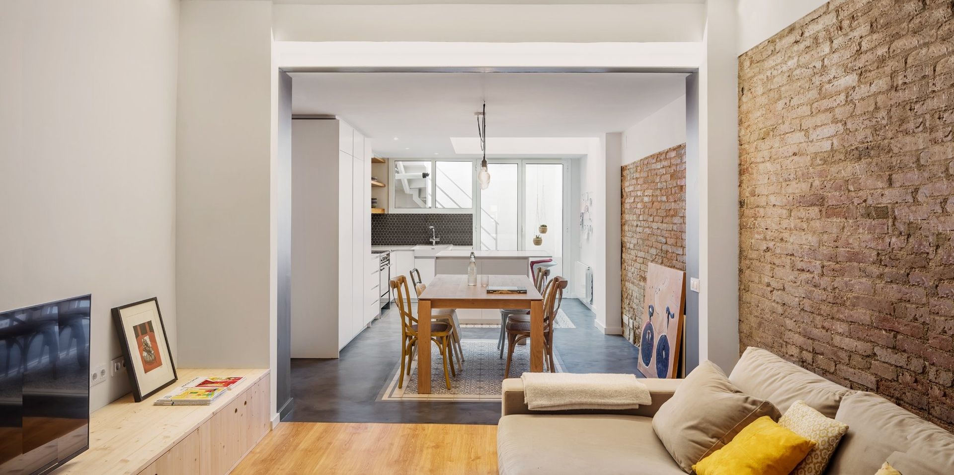 Una sala de estar con un sofá y un televisor de pantalla plana.