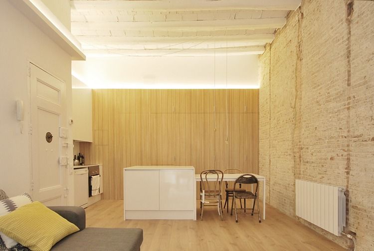 Una sala de estar con un sofá, una mesa y sillas.