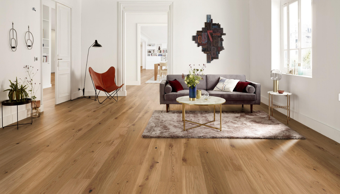 Una sala de estar vacía con pisos de madera y paredes blancas.