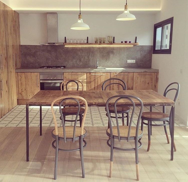Una cocina con una mesa y sillas de madera.