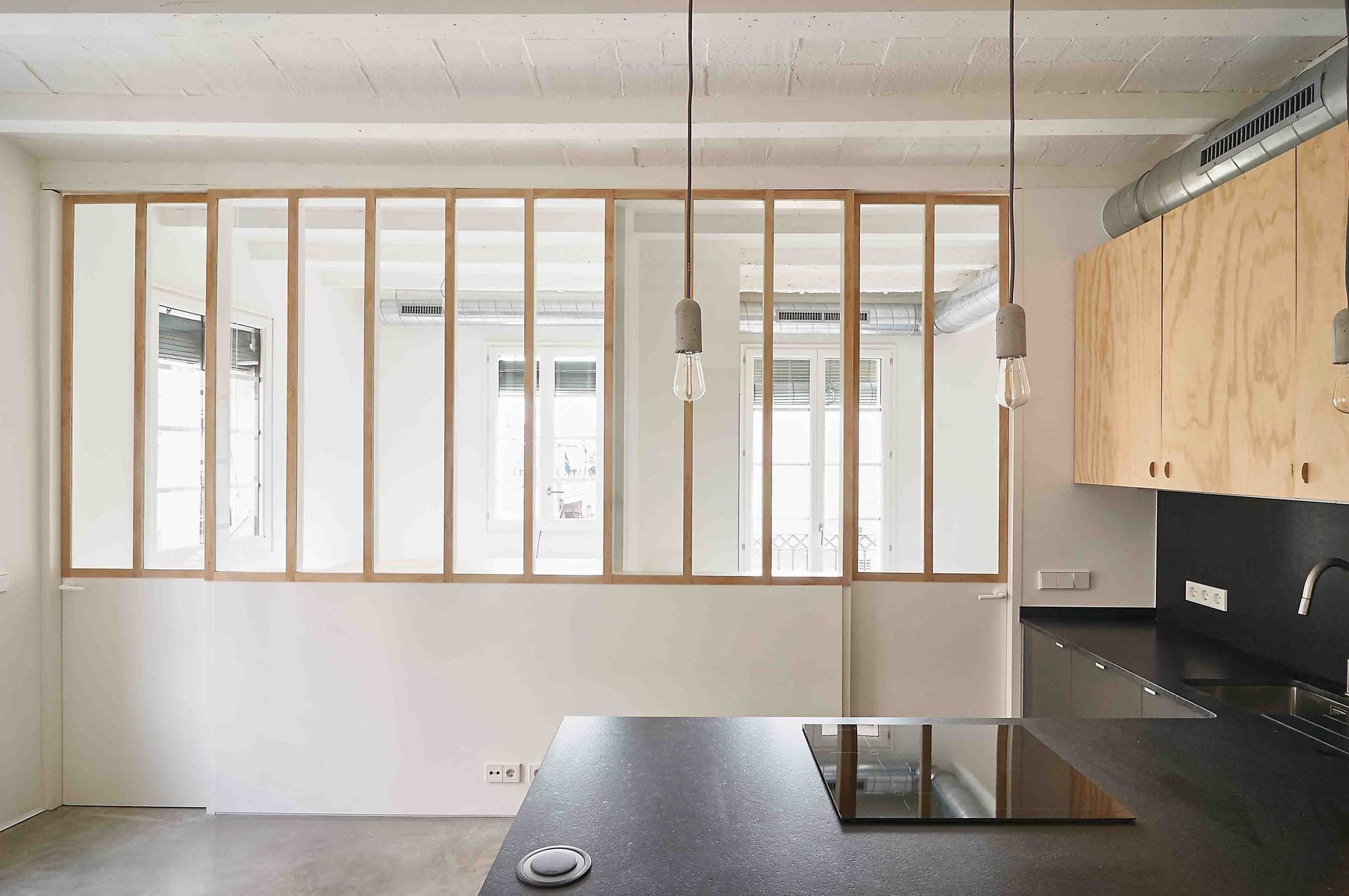 Una cocina con muchas ventanas y una encimera negra.