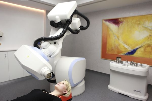 Eine Frau liegt unter dem CyberKnife in einer Arztpraxis