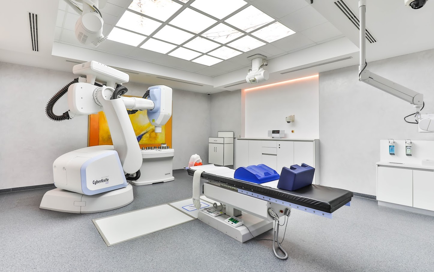 Operationsroboter in einem sterilen, hellen Operationssaal mit weißem Tisch und Deckenbeleuchtung.