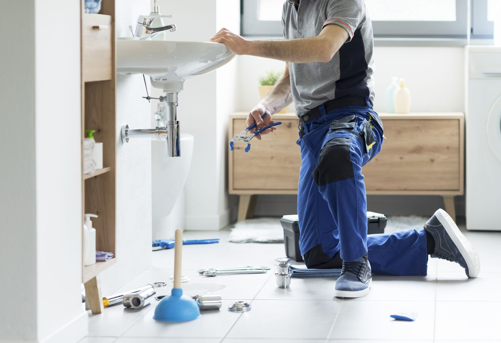 Plombier à genoux pour une installation d'évier