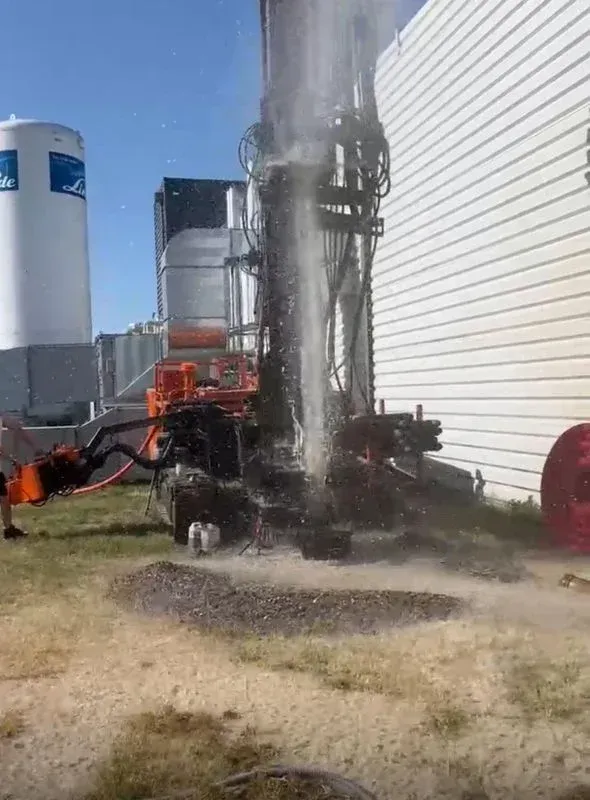 Eau qui jaillit du sol après un forage