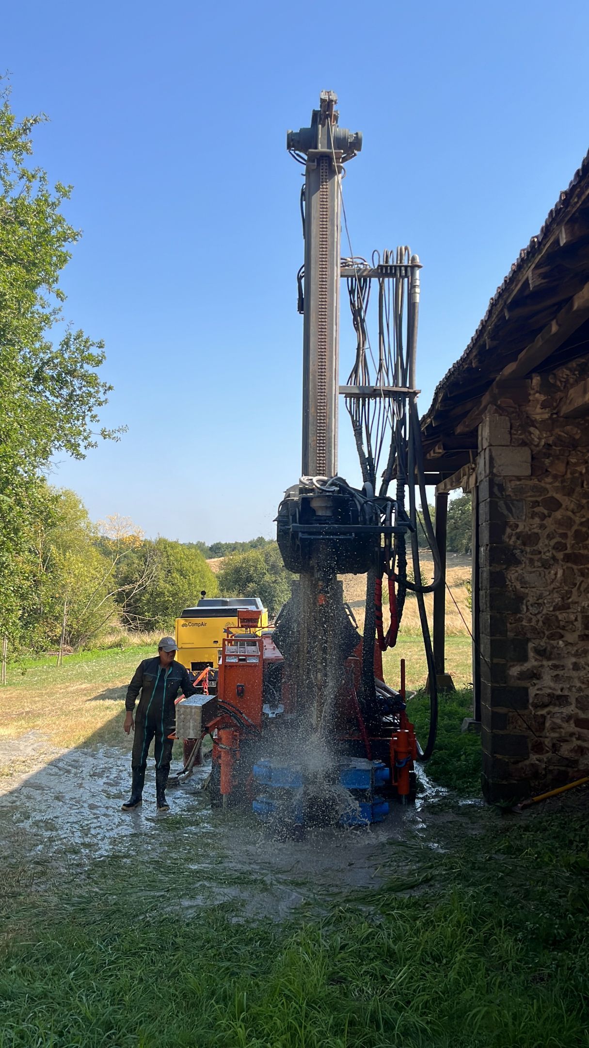 Foreuse devant un geyser d'eau