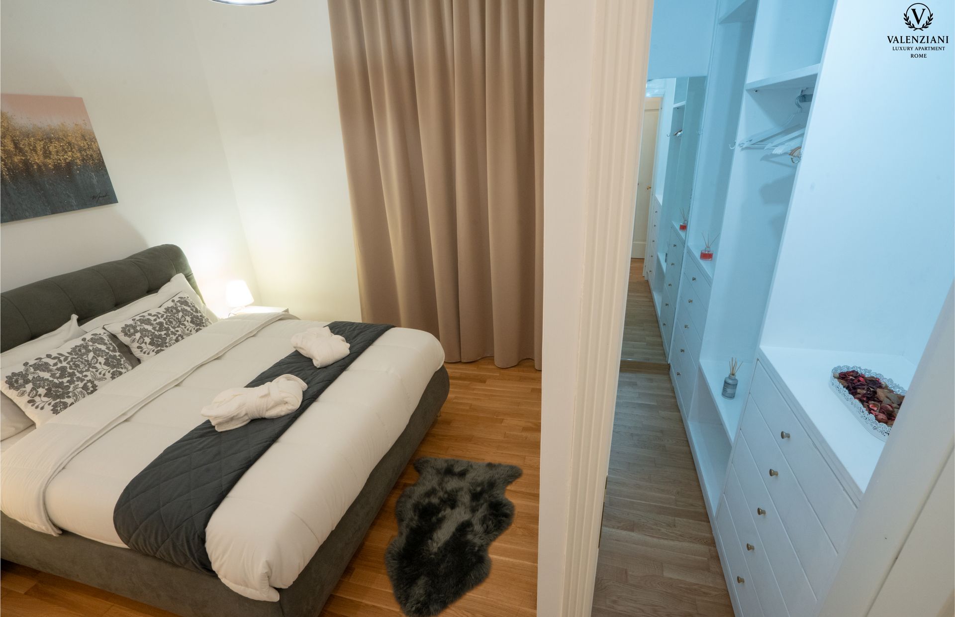 Bedroom with bed, rug, and walk-in closet. Neutral tones.
