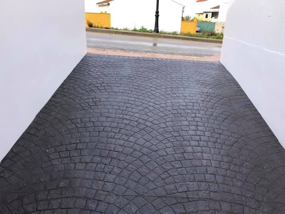 Un camino adoquinado negro que conduce a una calle