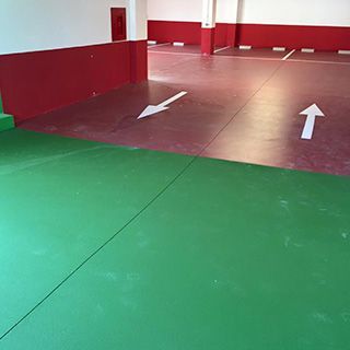 Un estacionamiento con pisos verdes y paredes rojas.