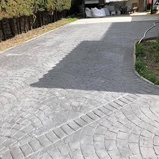 Un camino de entrada de hormigón con un dibujo de huellas de neumáticos.