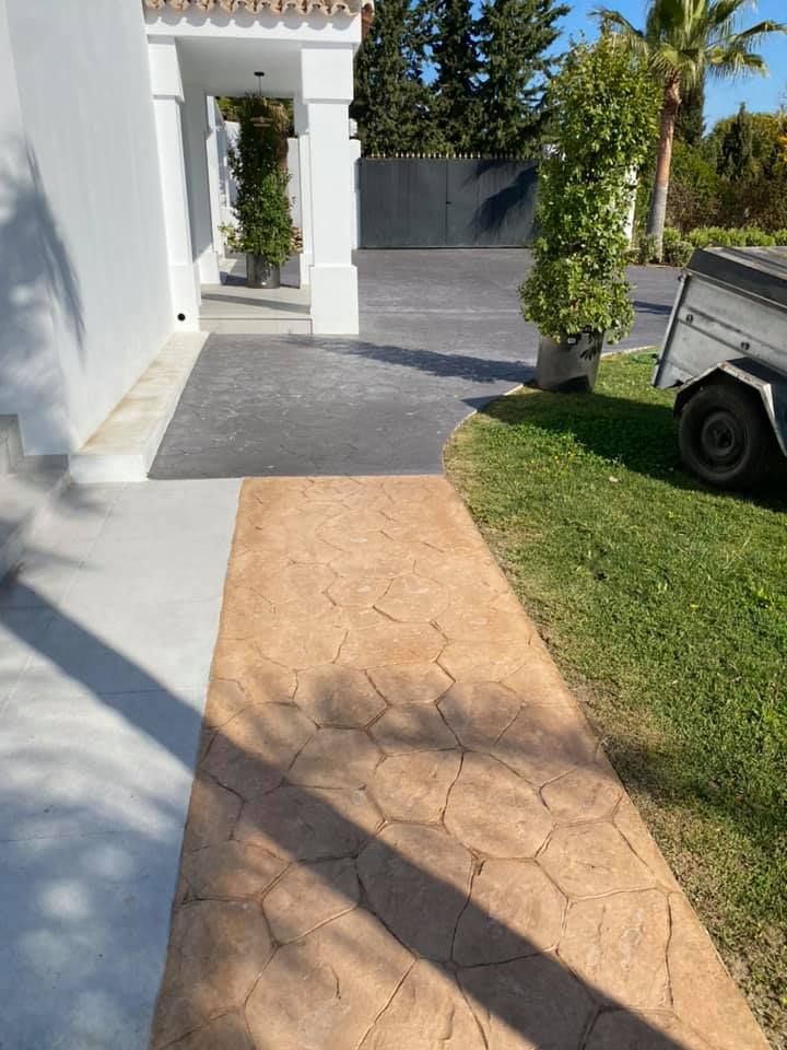 Una pasarela que conduce a una casa con un remolque estacionado en el césped.