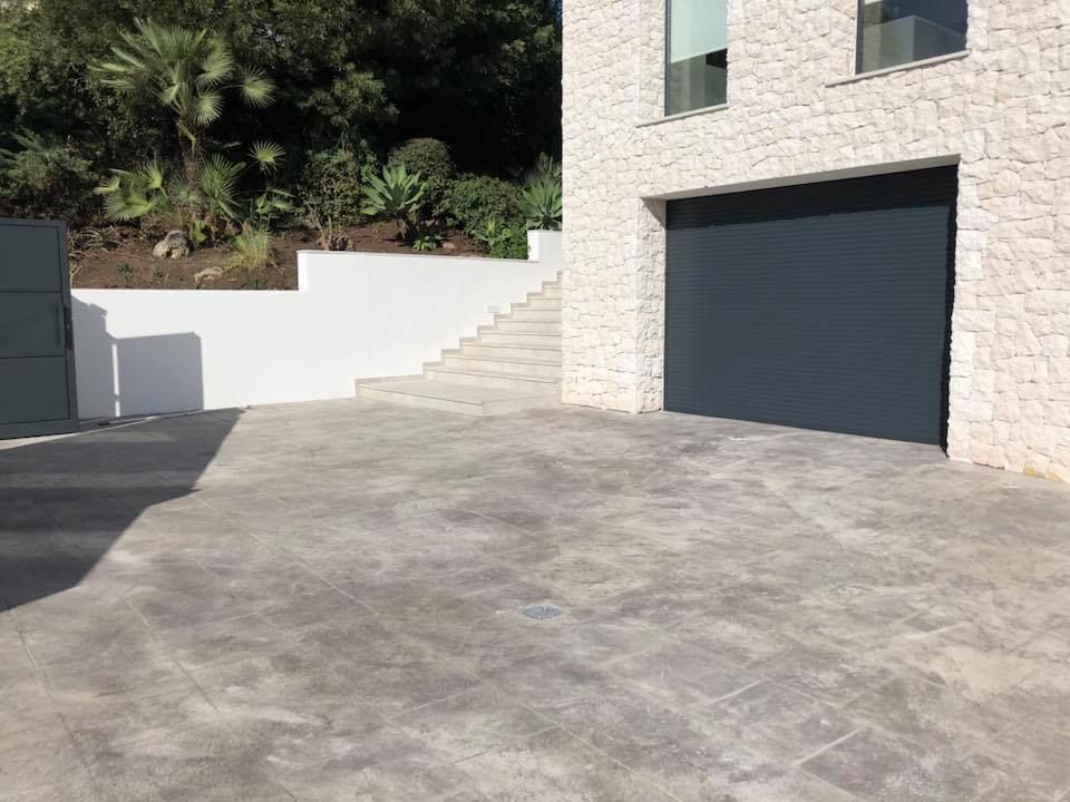 Un camino de entrada con puerta de garaje y escaleras que conducen a él.