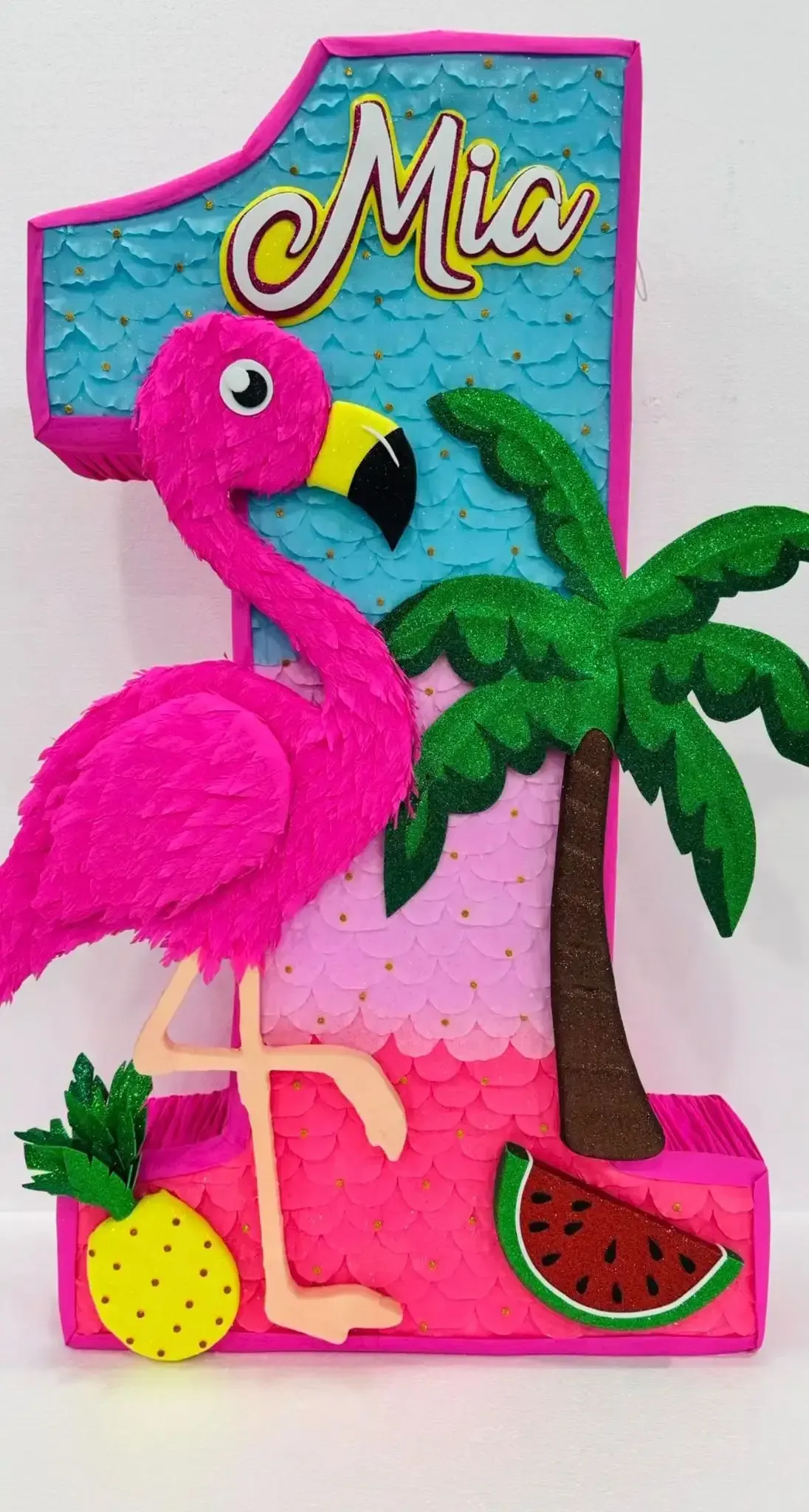 Decoración de flamenco rosa con “Mia”, palmera, piña y sandía en un colorido cartel de fiesta.