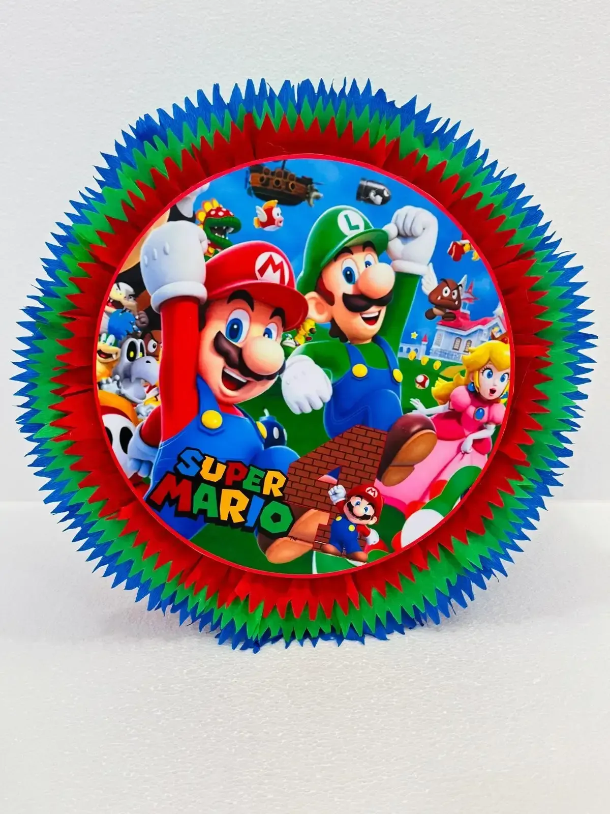 Personajes de Super Mario en una colorida decoración circular en forma de abanico con púas rojas, azules y verdes.