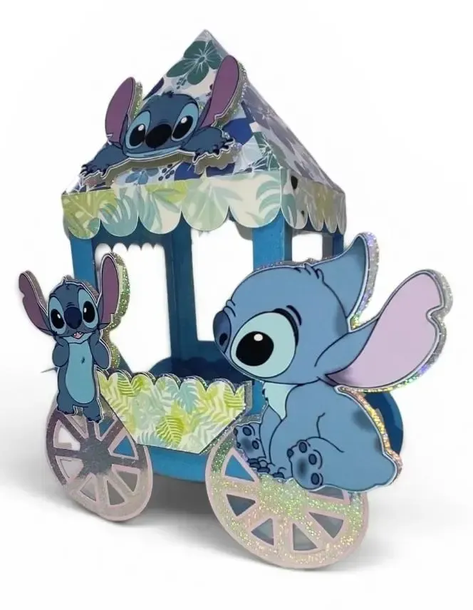 Carrito de manualidades de papel con temática de Blue Stitch, con ruedas y adornos florales, que incluye pequeños recortes de personajes.
