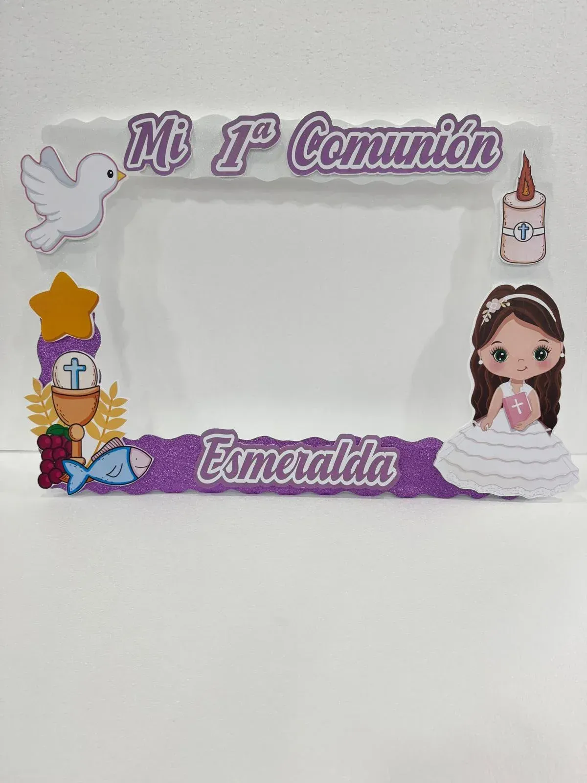 Marco de “Mi Primera Comunión” con ilustración de una paloma, una vela y una niña, etiquetado como “Esmeralda”.