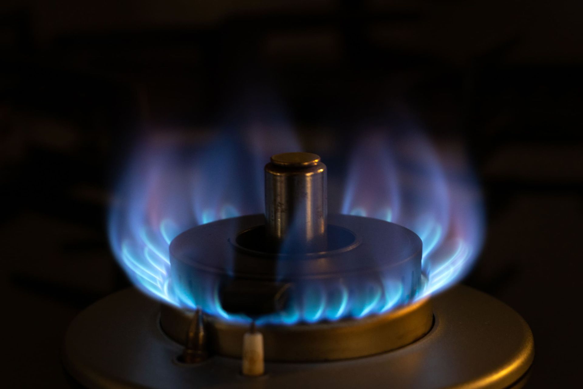 Un primer plano de un quemador de gas con una llama azul.