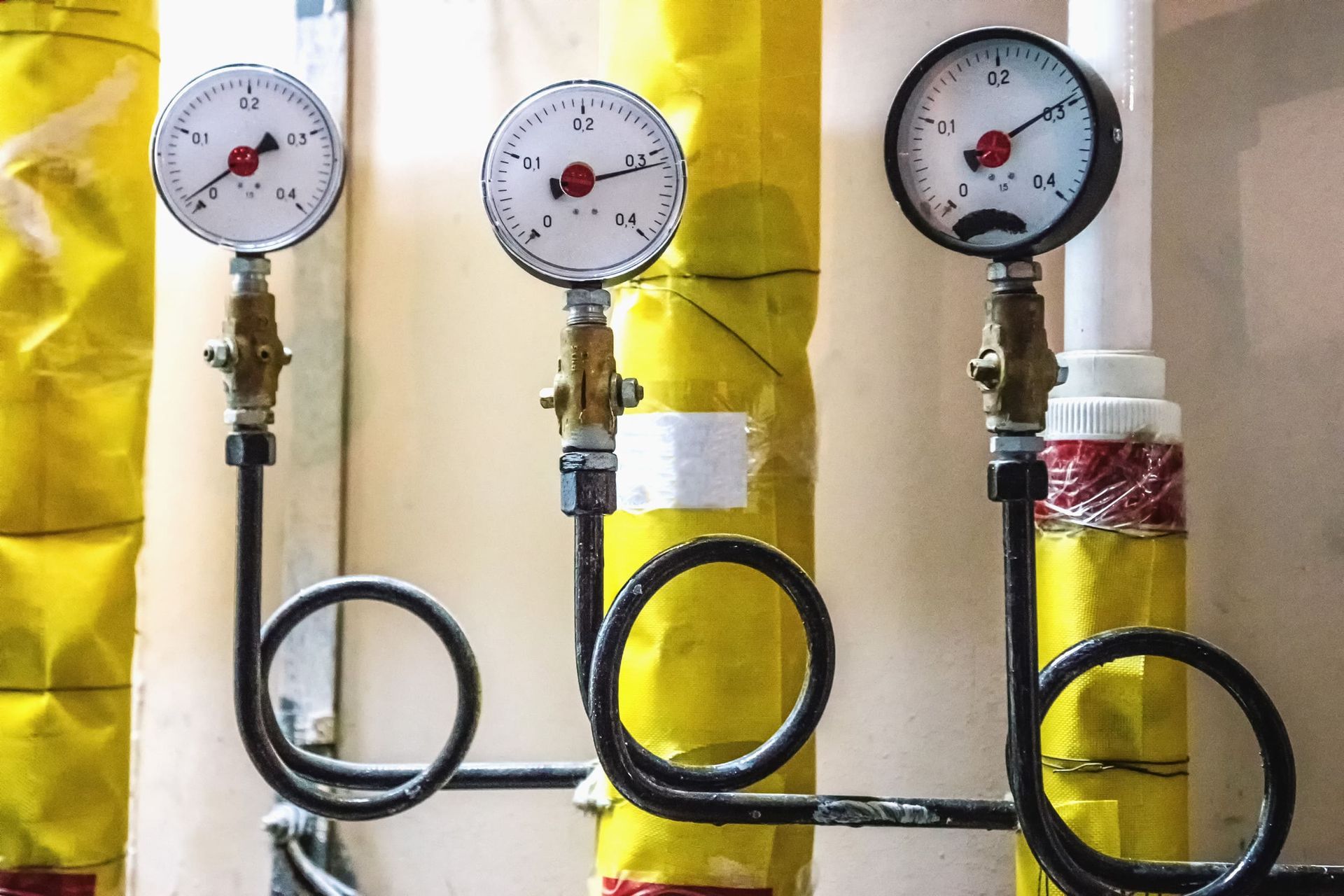 Hay tres manómetros encima de tubos amarillos.