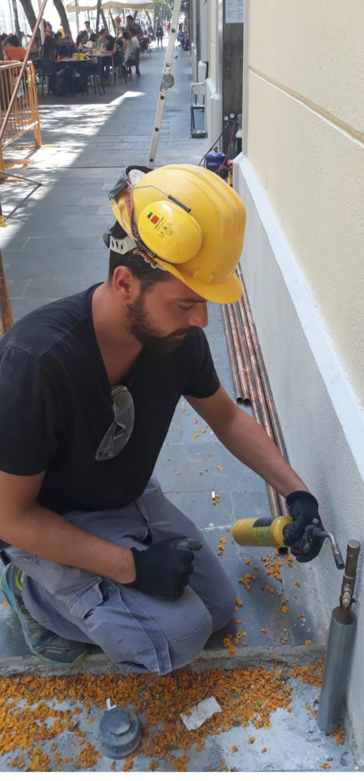 Un primer plano de una tubería de cobre en una pared de acero inoxidable.