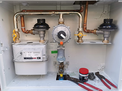 Un medidor de gas está dentro de una caja con tubos de cobre.