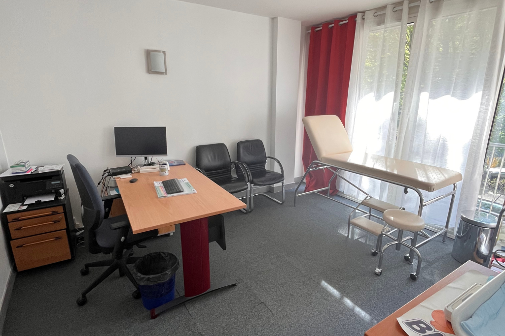 Il y a un ordinateur portable sur le bureau au milieu de la pièce.