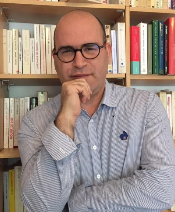 Un salon avec un bureau et des chaises et un ordinateur portable dessus.