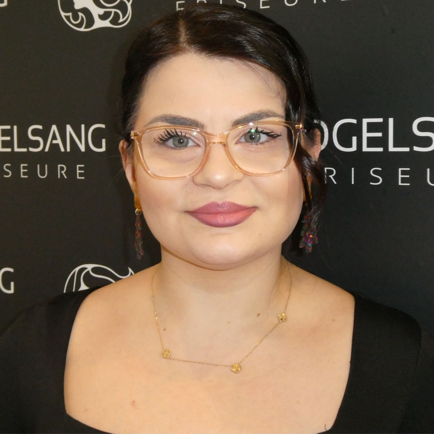 Ein Mann im karierten Hemd lächelt und hat die Arme verschränkt.