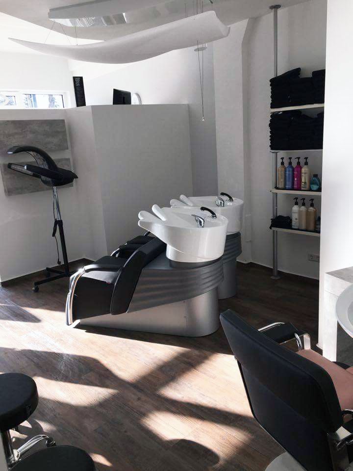 Ein Friseursalon mit zwei Waschbecken und einem Stuhl