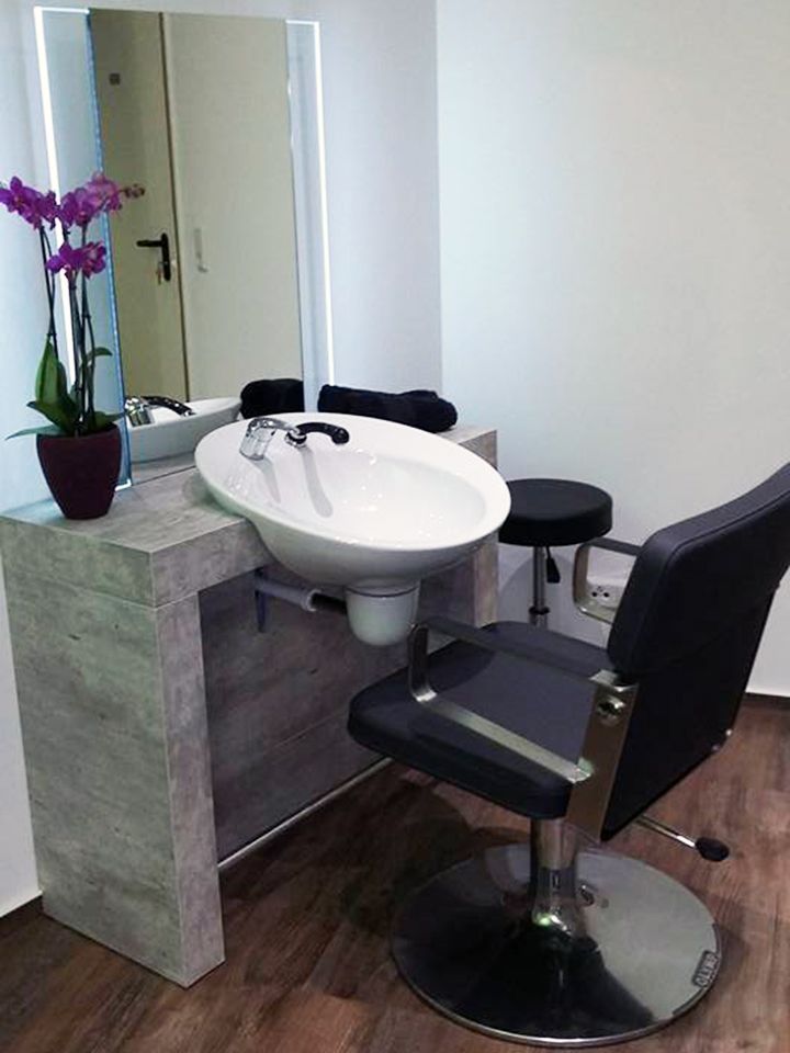 Ein Friseursalon mit Stuhl und Waschbecken