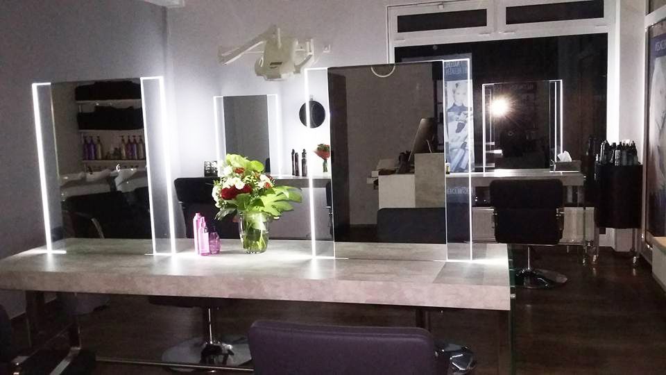 Ein Salon mit Tisch und Stühlen und einer Vase mit Blumen